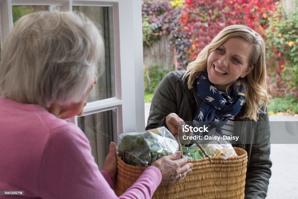 Female Neighbor Helping Senior Woman With Shopping